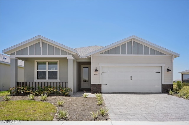 44385 Frontier Dr, Punta Gorda, FL 33982 - craftsman house featuring decorative driveway, a porch, a garage, and board and batten siding