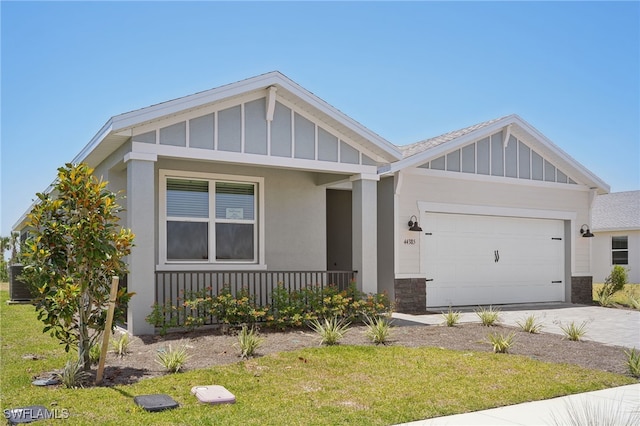 44385 Frontier Dr, Punta Gorda, FL 33982 - view of front of home with board and batten siding, an attached garage, a porch, concrete driveway, and a front lawn