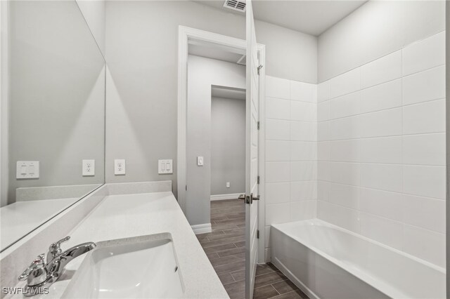 44385 Frontier Dr, Punta Gorda, FL 33982 - full bath with wood tiled floors, vanity, baseboards, and bathing tub / shower combination
