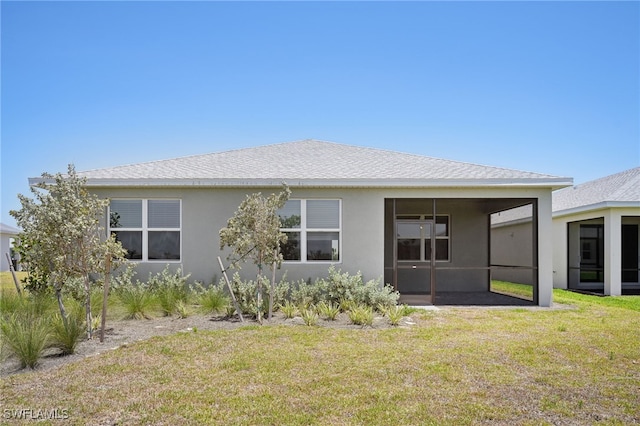 44385 Frontier Dr, Punta Gorda, FL 33982 - back of house featuring a sunroom, stucco siding, a lawn, and a shingled roof