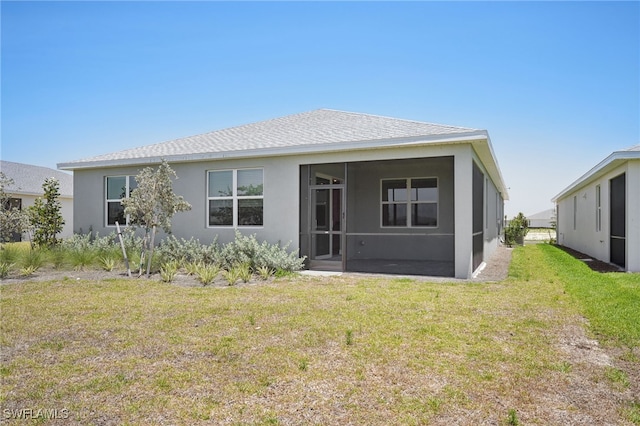 44385 Frontier Dr, Punta Gorda, FL 33982 - back of house with a sunroom, stucco siding, a yard, and roof with shingles