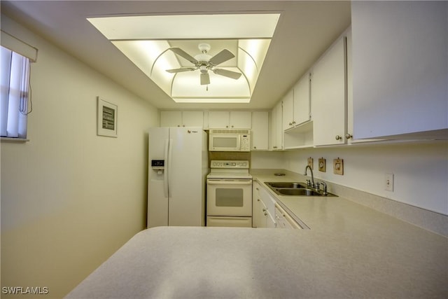 kitchen featuring white appliances, white cabinetry, a ceiling fan, a sink, and a raised ceiling