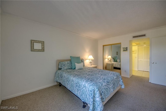 bedroom featuring carpet flooring, visible vents, a closet, and baseboards
