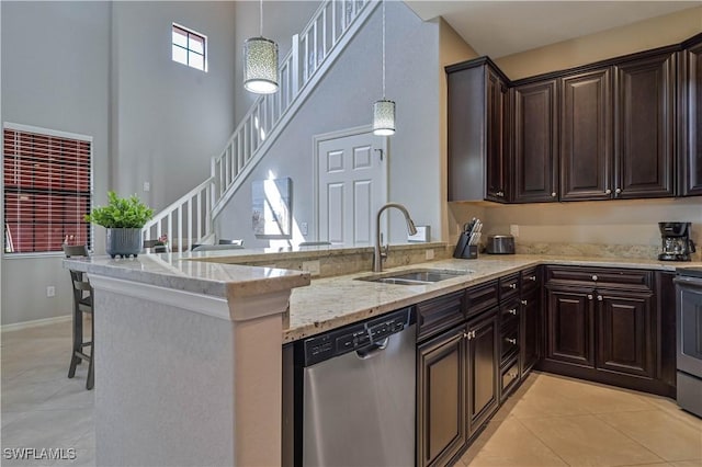 11296 Paseo Grande Blvd Unit 5806, Fort Myers, FL 33912 - kitchen featuring dishwasher, a sink, a peninsula, light tile patterned flooring, and light stone counters
