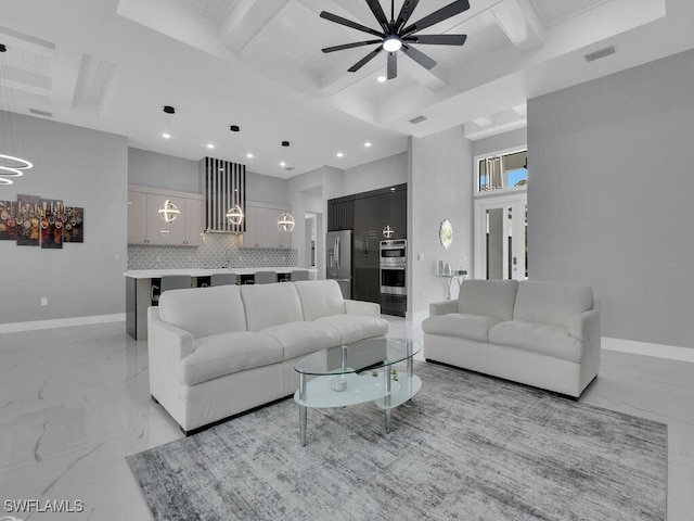 living room featuring ceiling fan with notable chandelier, marble finish floor, baseboards, and beam ceiling
