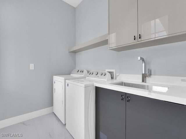 clothes washing area with baseboards, washer and dryer, a sink, cabinet space, and marble finish floor