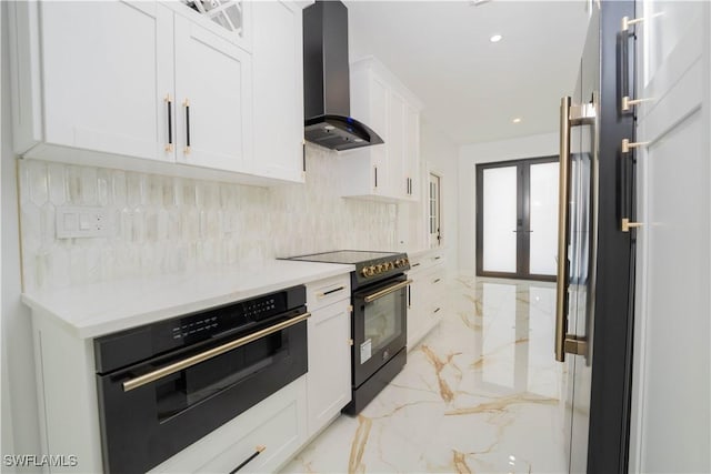 1603 E 5th St, Lehigh Acres, FL 33972 - kitchen featuring wall chimney exhaust hood, black appliances, light marble finish floors, tasteful backsplash, and white cabinetry