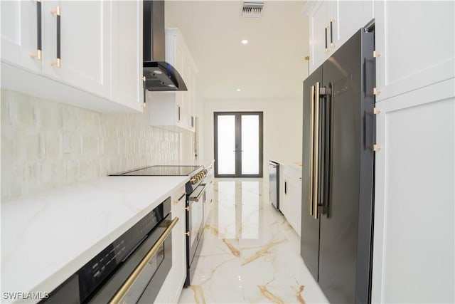 1603 E 5th St, Lehigh Acres, FL 33972 - kitchen with light marble finish flooring, wall chimney exhaust hood, appliances with stainless steel finishes, white cabinets, and recessed lighting