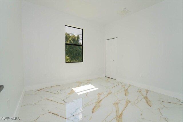 1603 E 5th St, Lehigh Acres, FL 33972 - empty room with marble tiled flooring and baseboards