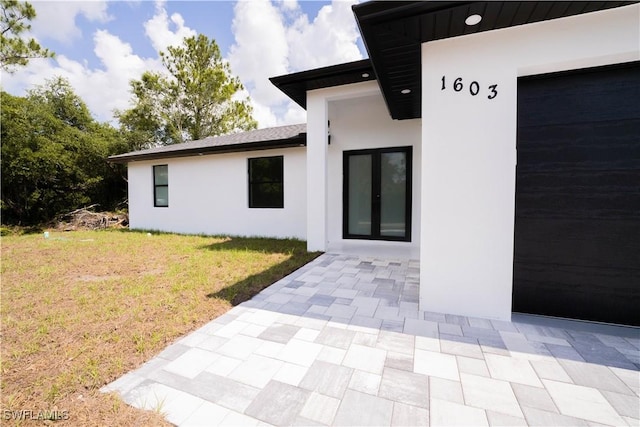 1603 E 5th St, Lehigh Acres, FL 33972 - entrance to property with a lawn, stucco siding, and a patio