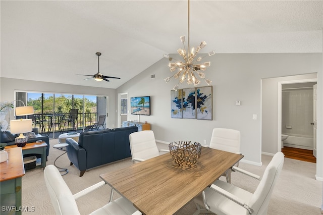 dining room featuring ceiling fan with notable chandelier, light colored carpet, baseboards, and vaulted ceiling