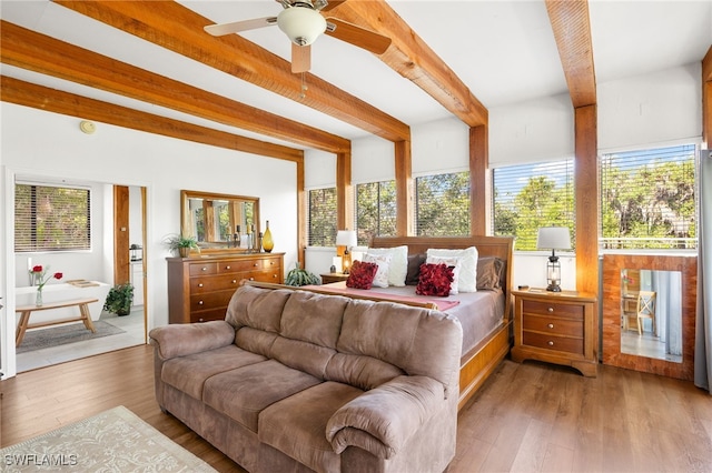 bedroom featuring multiple windows, wood finished floors, and beamed ceiling