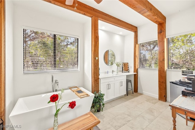interior space featuring a freestanding bath, a ceiling fan, plenty of natural light, and vanity