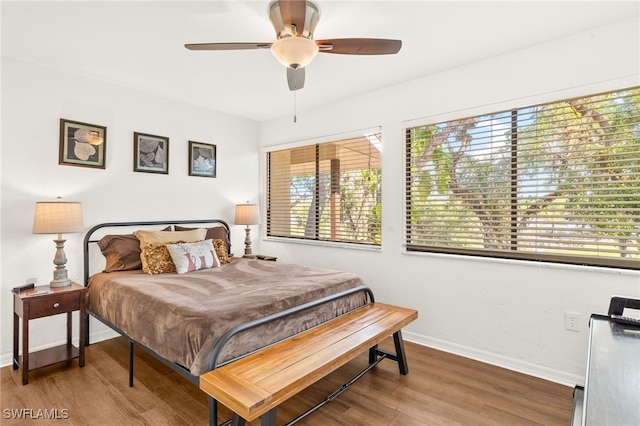 bedroom with wood finished floors, baseboards, and a ceiling fan