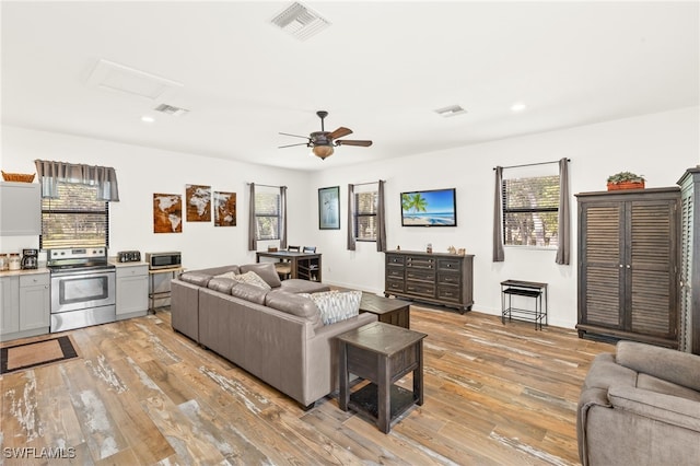 living area with light wood-style floors, visible vents, a ceiling fan, and recessed lighting