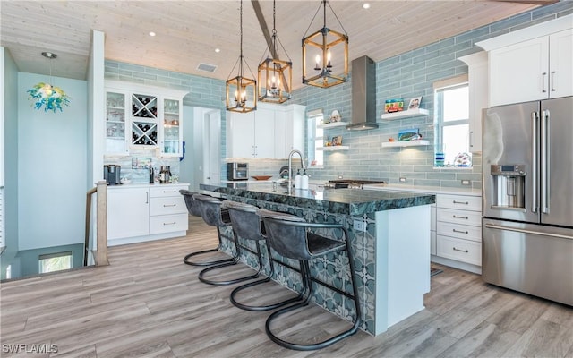 4620 Oro Pesos Ln, Upper Captiva, FL 33924 - kitchen featuring high quality fridge, tasteful backsplash, white cabinets, light wood-style flooring, and wood ceiling