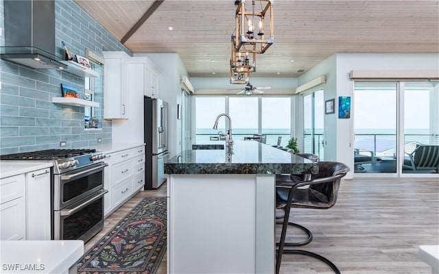4620 Oro Pesos Ln, Upper Captiva, FL 33924 - kitchen featuring stainless steel appliances, wood ceiling, a kitchen bar, a kitchen island with sink, and white cabinetry