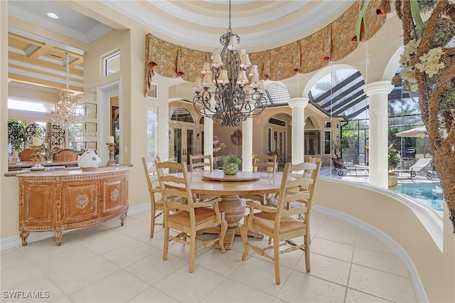 dining room with a high ceiling, decorative columns, a notable chandelier, and ornamental molding