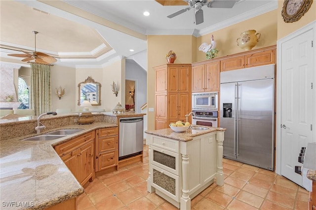 kitchen featuring ceiling fan, ornamental molding, light stone counters, a sink, and built in appliances