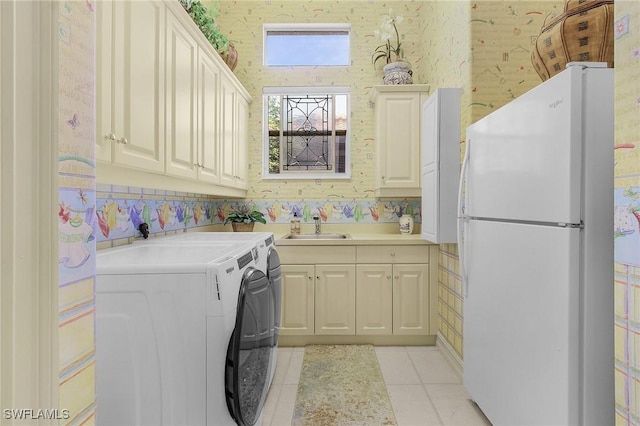 laundry area featuring a sink, light tile patterned floors, and wallpapered walls