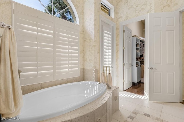 bathroom featuring a garden tub, plenty of natural light, and wallpapered walls