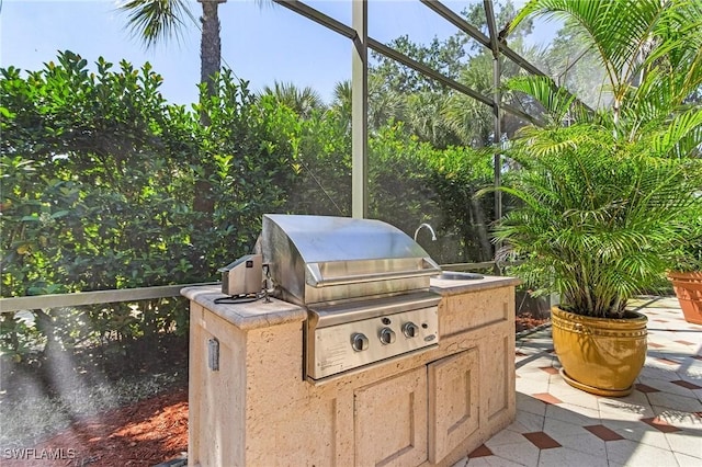 view of patio with glass enclosure and area for grilling