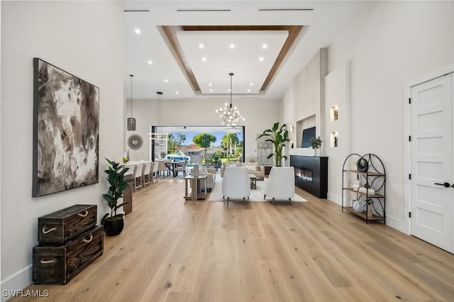 127 SW 56th Ter, Cape Coral, FL 33914 - living room with light wood-type flooring, a tray ceiling, an inviting chandelier, and recessed lighting