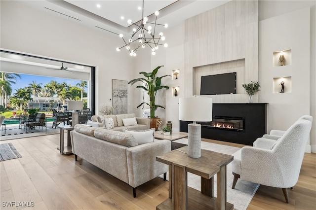 127 SW 56th Ter, Cape Coral, FL 33914 - living area with light wood finished floors, a glass covered fireplace, a towering ceiling, recessed lighting, and ceiling fan