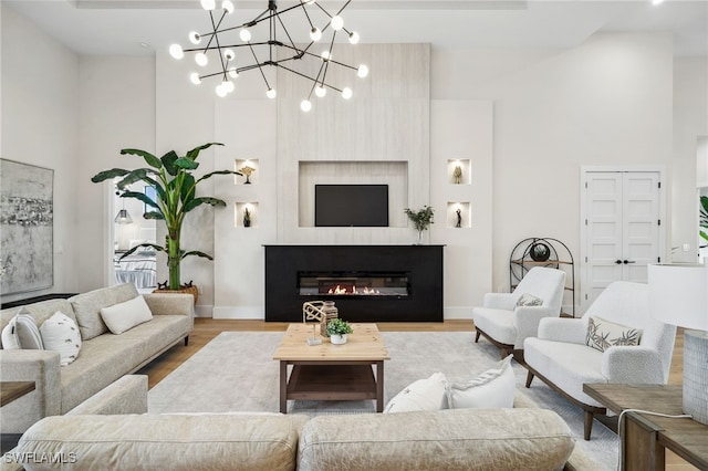 127 SW 56th Ter, Cape Coral, FL 33914 - living room featuring a glass covered fireplace, baseboards, wood finished floors, and a towering ceiling