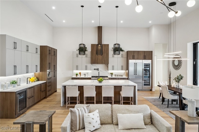 127 SW 56th Ter, Cape Coral, FL 33914 - kitchen featuring light wood-style floors, stainless steel built in refrigerator, a towering ceiling, and wine cooler