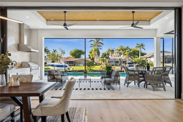 127 SW 56th Ter, Cape Coral, FL 33914 - interior space featuring a tray ceiling, wood finished floors, a ceiling fan, and plenty of natural light