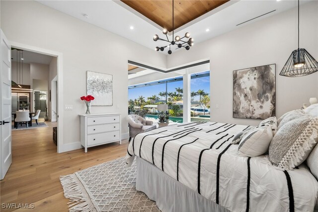 127 SW 56th Ter, Cape Coral, FL 33914 - bedroom with access to exterior, a towering ceiling, recessed lighting, a chandelier, and light wood-style floors
