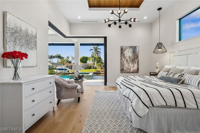 127 SW 56th Ter, Cape Coral, FL 33914 - bedroom featuring a notable chandelier, light wood-style flooring, access to exterior, and multiple windows