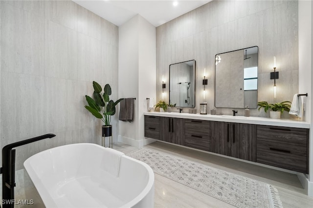 127 SW 56th Ter, Cape Coral, FL 33914 - full bath with wood finished floors, a sink, double vanity, a freestanding bath, and a high ceiling