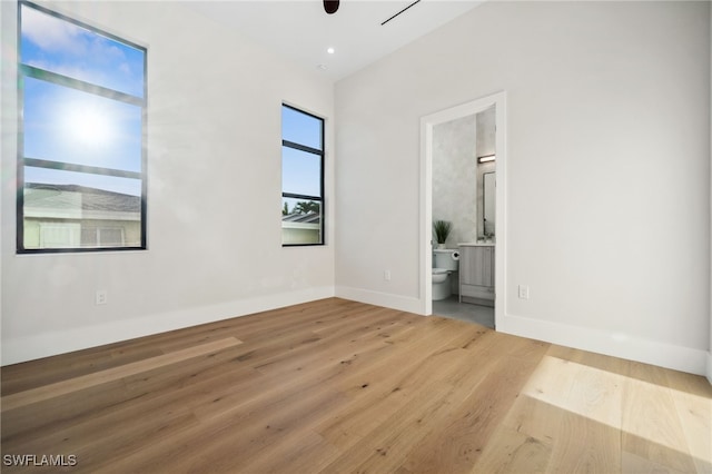127 SW 56th Ter, Cape Coral, FL 33914 - unfurnished bedroom featuring wood finished floors, baseboards, and ensuite bathroom