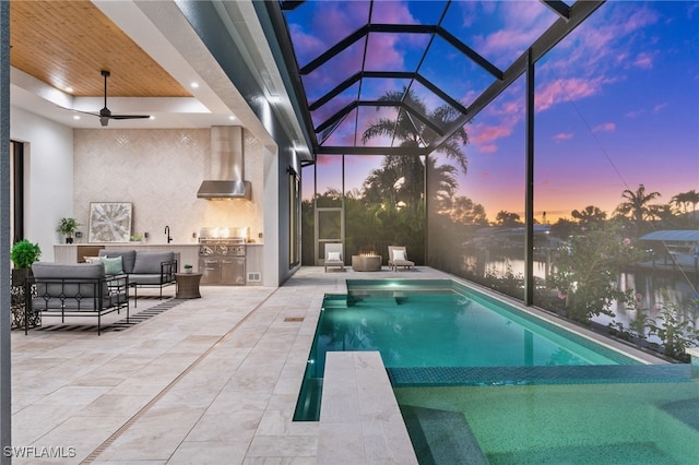 127 SW 56th Ter, Cape Coral, FL 33914 - pool at dusk featuring glass enclosure, outdoor lounge area, a patio, exterior kitchen, and area for grilling