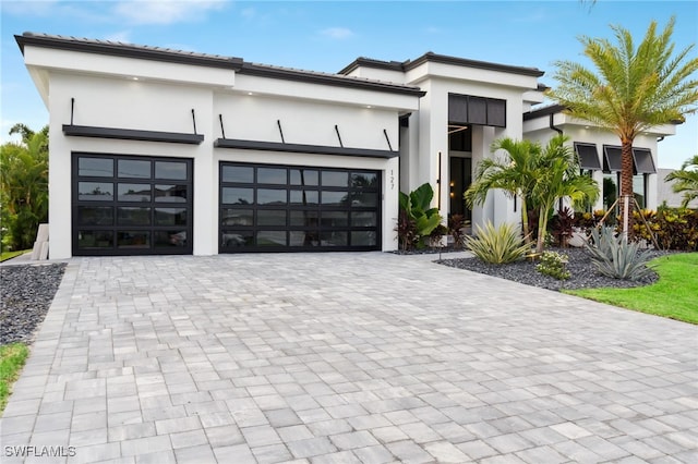 127 SW 56th Ter, Cape Coral, FL 33914 - contemporary home featuring stucco siding, an attached garage, and decorative driveway