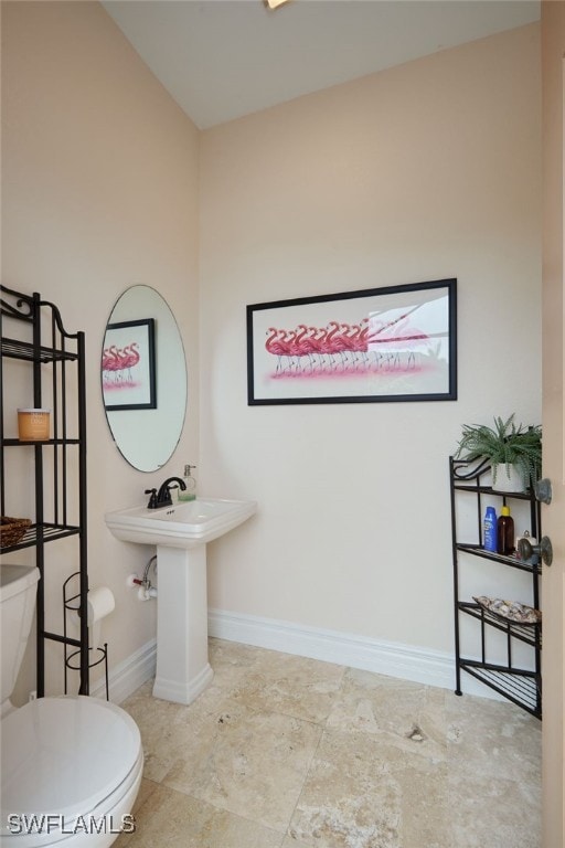 half bathroom with toilet and baseboards
