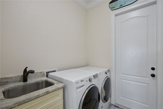 laundry room with cabinet space, washer and dryer, ornamental molding, and a sink