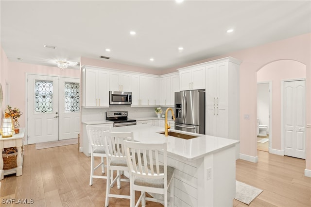5794 Elizabeth Ann Way, Fort Myers, FL 33912 - kitchen featuring a sink, light countertops, arched walkways, and stainless steel appliances
