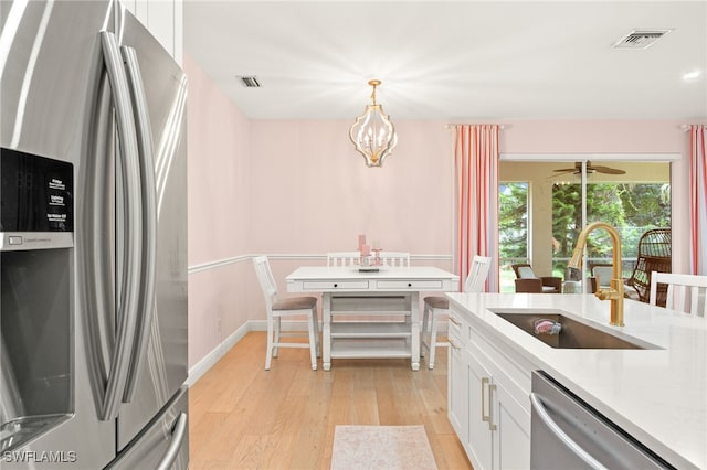 5794 Elizabeth Ann Way, Fort Myers, FL 33912 - kitchen with a sink, visible vents, light wood-style flooring, and stainless steel appliances