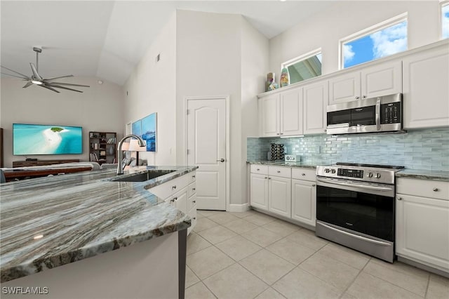 kitchen with light tile patterned floors, a ceiling fan, white cabinetry, appliances with stainless steel finishes, and backsplash