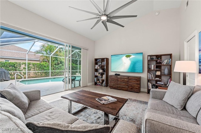 tiled living room with high vaulted ceiling, a ceiling fan, a sunroom, and baseboards