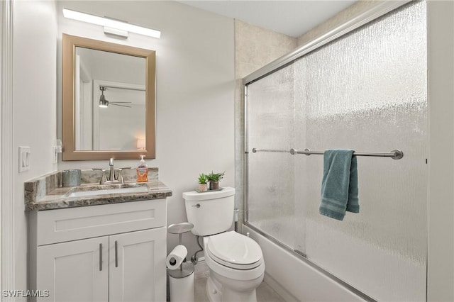 bathroom featuring toilet, vanity, and bath / shower combo with glass door