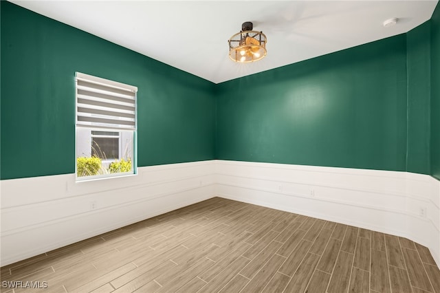 spare room with wood finished floors and baseboards