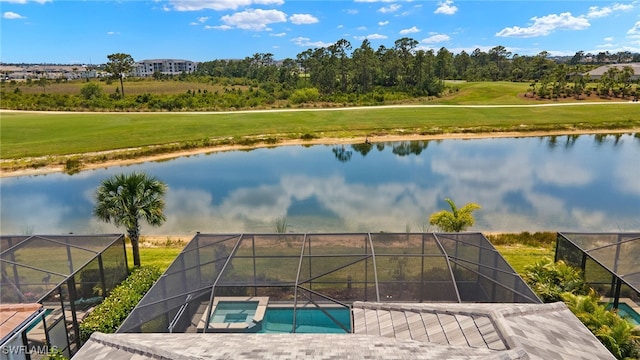 drone / aerial view with view of golf course and a water view