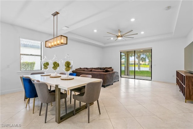 dining room with a raised ceiling, baseboards, and recessed lighting