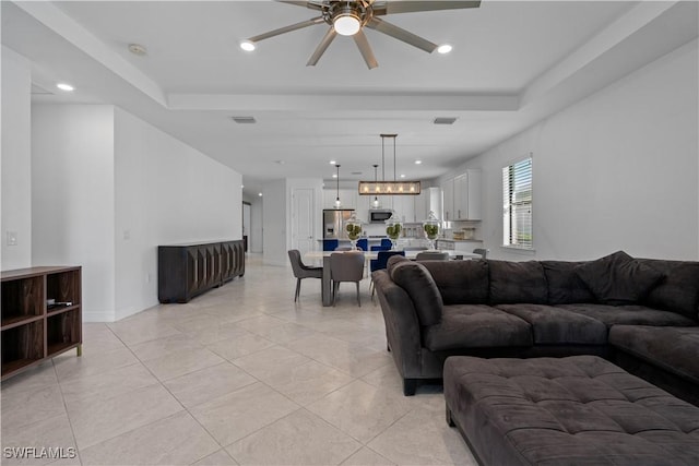 living room with visible vents, a raised ceiling, recessed lighting, and a ceiling fan