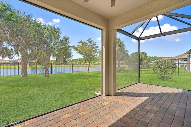 unfurnished sunroom featuring a water view and a ceiling fan
