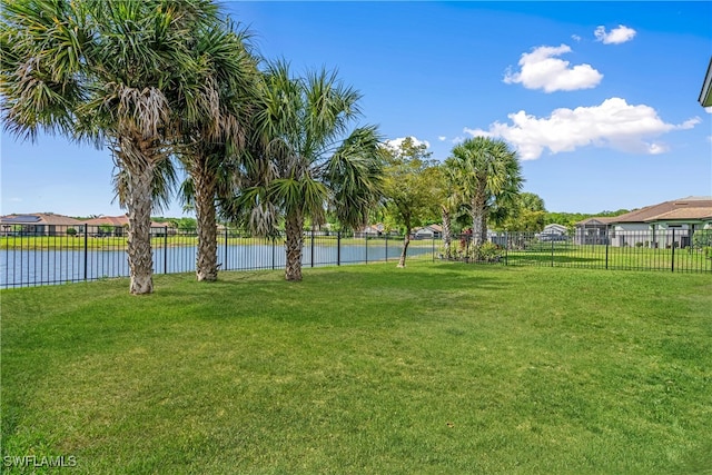 view of yard with a water view and fence
